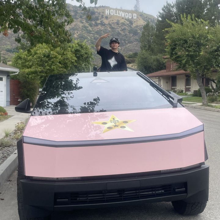 man in front of hollywood sign pink tesla cybertruck driving experience