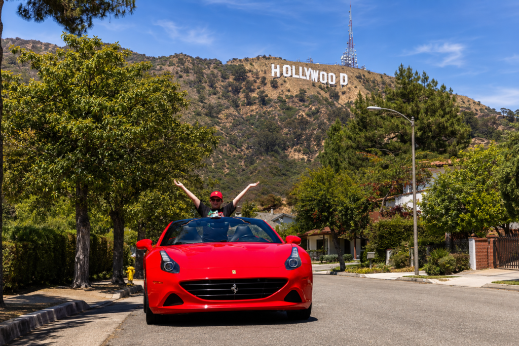kid posing at the hollywood sign with red ferrari one of the unique things to do with kids in los angeles