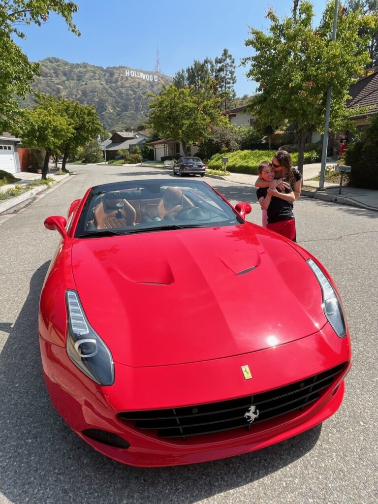 mom and son posing at the hollywood sign with ferrari one of the unique things to do with kids in los angeles