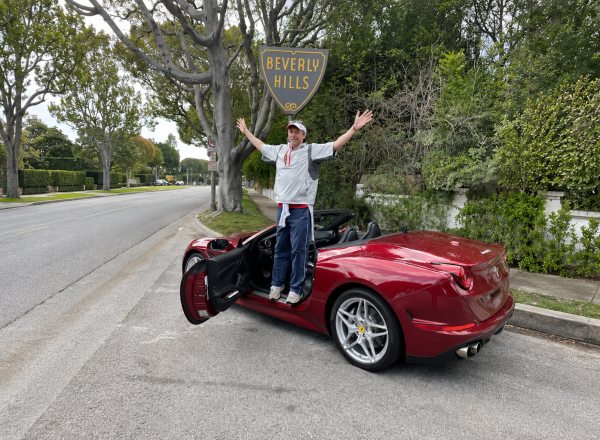 guest posing with red ferrari california t under the beverly hills sign one of the unique things to do in Los Angeles